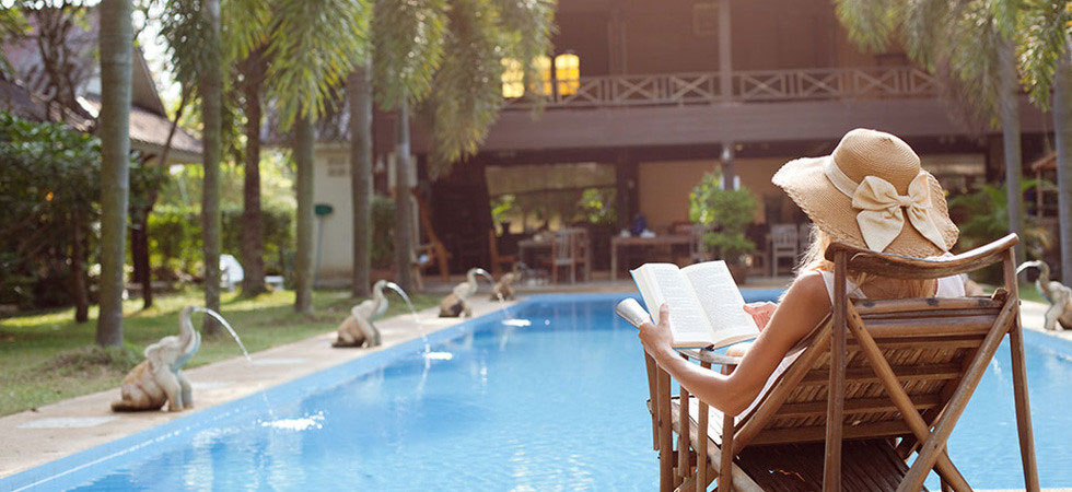 Chica leyendo disfrutando de sus vacaciones con AC Real.